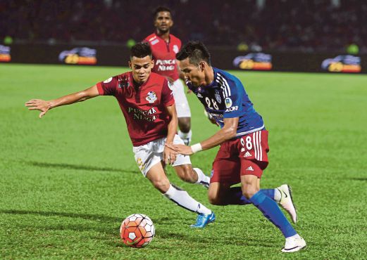 AZINEE (kanan) melepasi kawalan pemain PDRM di Stadium Tan Sri Hassan Yunos, Larkin, kelmarin.