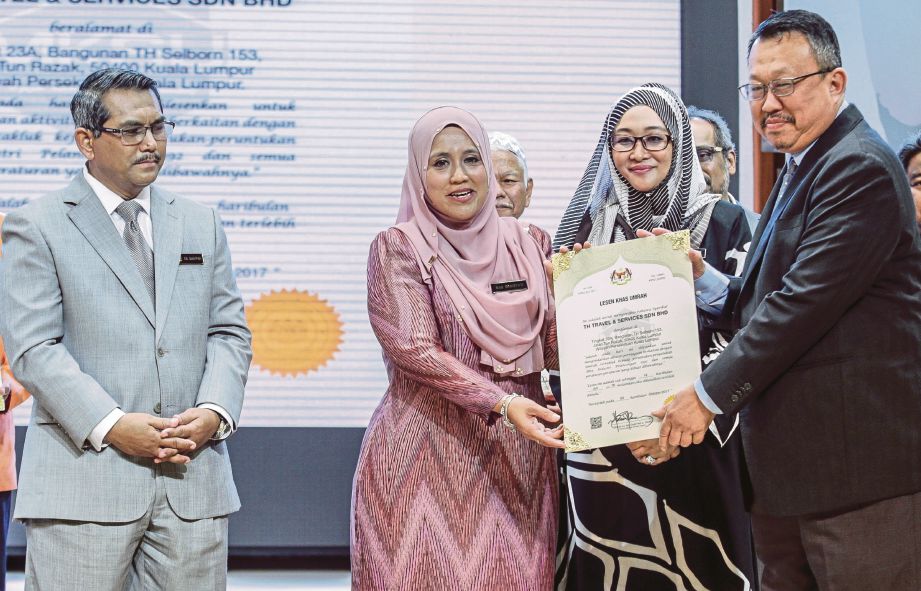 MAS Ermieyati menyampaikan replika Sijil Lesen Khas Umrah kepada Ketua Pegawai Eksekutif TH Travel & Services Sdn Bhd Datuk Khalid Noordin.