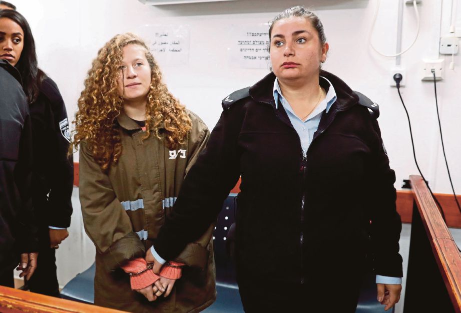 AHED (kiri) digari dan dikawal ketat ketika didakwa di sebuah mahkamah tentera Israel di Tebing Barat pada Isnin lalu. - AFP