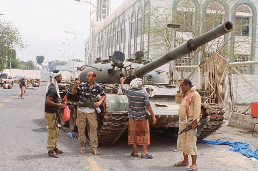 ANGGOTA militan Yaman yang dikenali Pergerakan Pemisah Selatan mengawal sebuah kereta kebal di daerah Tawahi, Aden, semalam.  