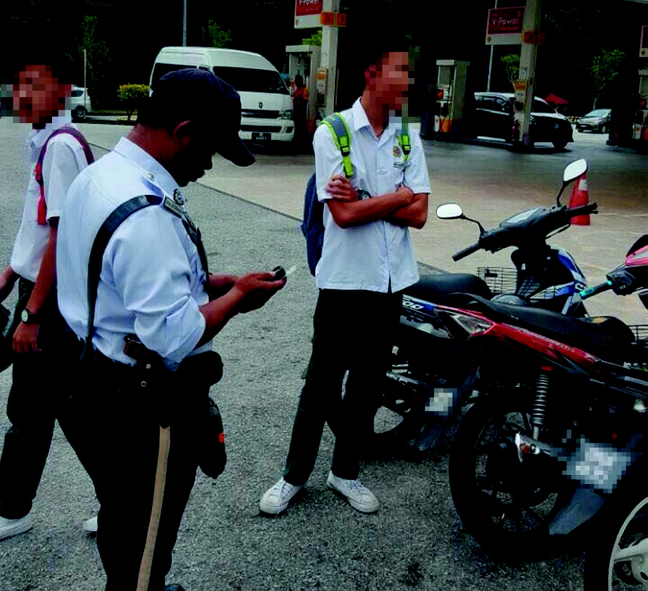  ANGGOTA polis trafik menjalankan pemeriksaan terhadap pelajar sekolah yang menunggang motosikal di SMK Bandar Kinrara 4.