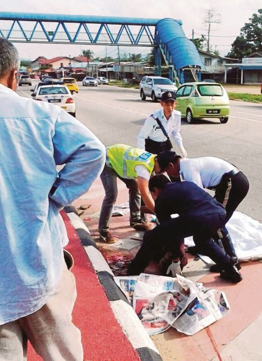 ANGGOTA polis mengangkat mayat mangsa yang terbabit nahas di Jalan Kota Bharu-Kuala Krai, semalam.