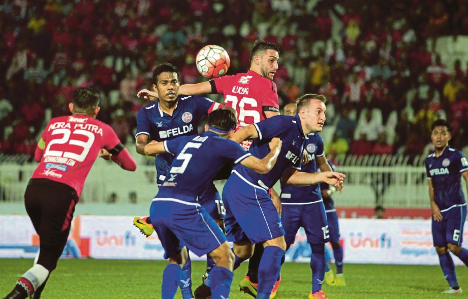   PEMAIN Kelantan  Blazhe Ilijoski (dua dari kanan) membuat tandukan di pintu gol FELDA. 
