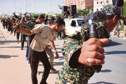 Pengikut Syiah Iraq memukul badan mereka dalam satu perarakan sempena sambutan  Asyura di Baghdad, semalam. 