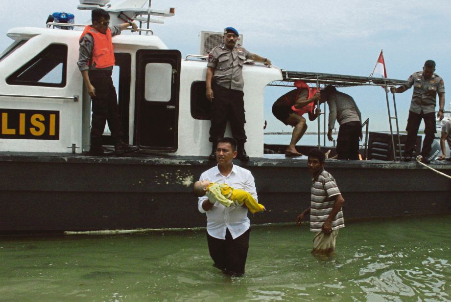 ANGGOTA polis mendukung mayat bayi dipercayai antara mangsa yang maut dalam tragedi bot karam di Batam, kelmarin. - AFP