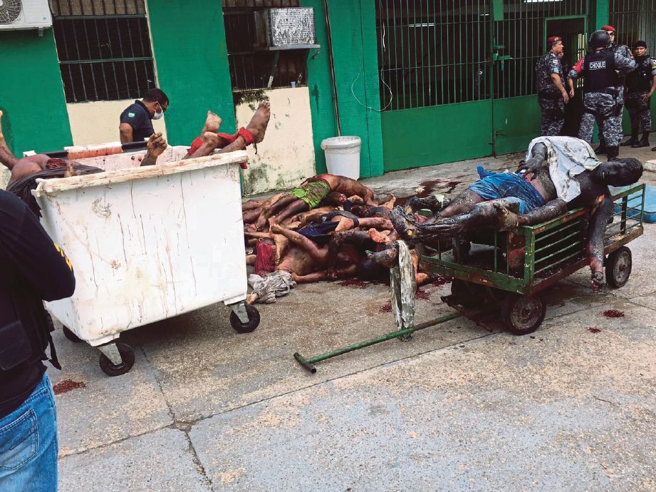 POLIS mengumpulkan mayat banduan yang terbunuh selepas rusuhan di penjara Anisio Jobim di Manaus, Brazil. - AFP