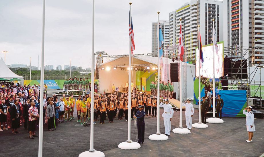 KONTINJEN negara bersemangat ketika upacara menaikkan Jalur Gemilang di perkampungan sukan.