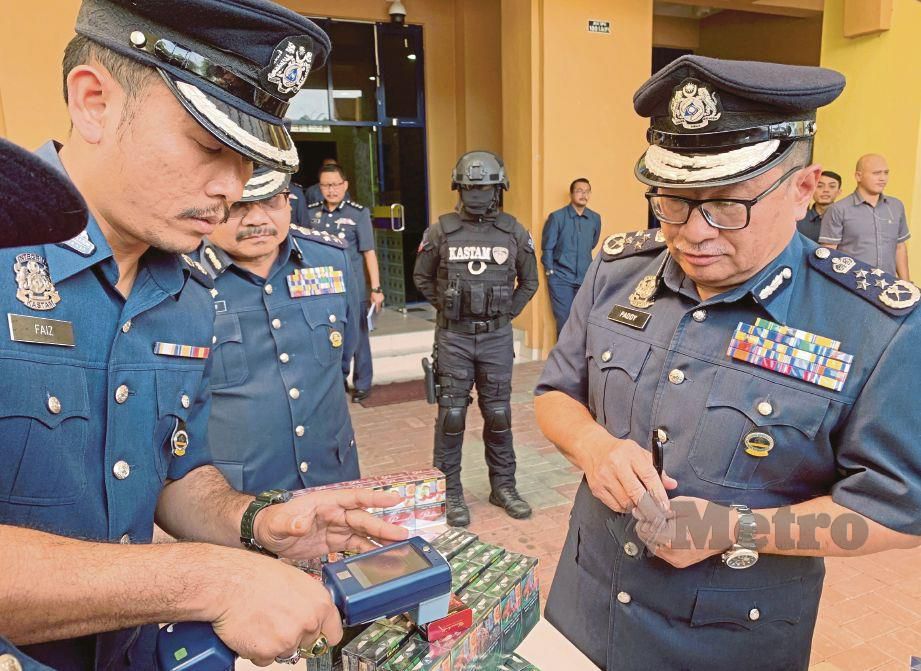 PADDY (kanan) melihat bagaimana rokok bersetem palsu dikenal pasti melalui alat pengesan khas di Pejabat Kastam Dengkil, semalam.