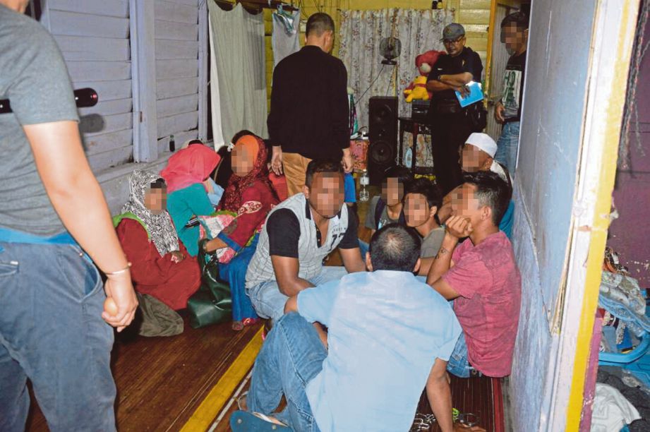 ANGGOTA imigresen menahan warga asing dalam Ops Ikrar di sekitar Padang Jawa untuk pemeriksaan lanjut.