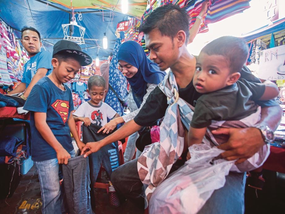 Ridwan Rusdi bersama keluarga ketika membeli pakaian persiapan Hari Raya Aidilfitri   di Jalan TAR. 