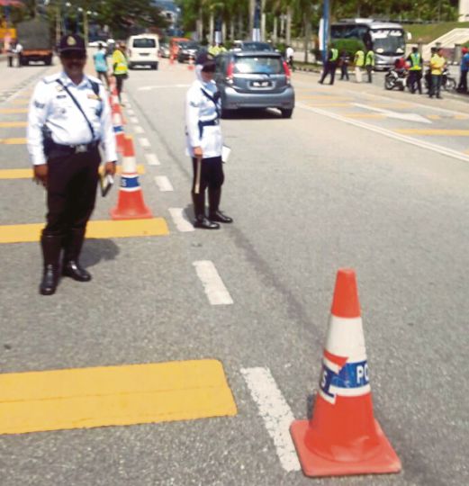 Anggota polis  melakukan  sekatan jalan raya untuk mengesan pesalah trafik.