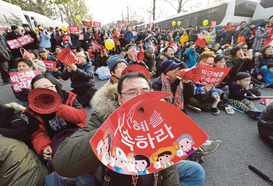 PENUNJUK perasaan melaungkan slogan menggesa Park meletak jawatan ketika mengadakan demonstrasi berhampiran istana presiden di Seoul, semalam.  - AP