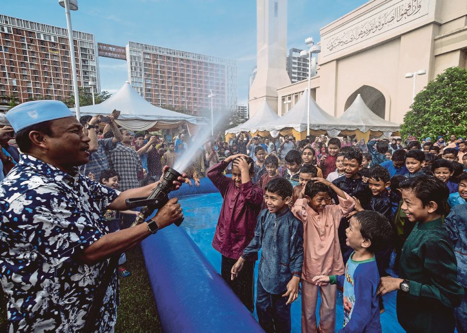  Pengerusi MAIS Datuk Mohamad Adzib Mohd Isa  memandikan peserta berkhatan pada   program Sunathon di Masjid Tengku Ampuan Jemaah.