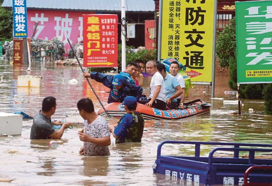 PASUKAN penyelamat memindahkan penduduk dari kawasan banjir di bandar Laudi di wilayah Hunan.  - EPA 