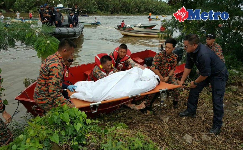ANGGOTA bomba mengangkat mayat selepas ditemui terapung di muara Sungai Bundusan, Papar. FOTO ihsan bomba