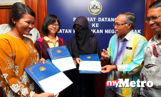 PENGARAH Jabatan Pendidikan Negeri Perak, Rozi Puteh Ismail (dua kanan) beramah mesra dengan penerima sijil keputusan SPM 2015 yang mendapat keputusan cemerlang. FOTO L Manimaran