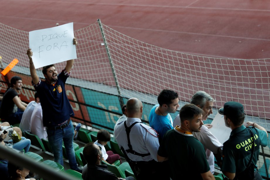 SEORANG penyokong Sepanyol menunjukkan sepanduk ‘Keluar Pique’. FOTO/REUTERS 