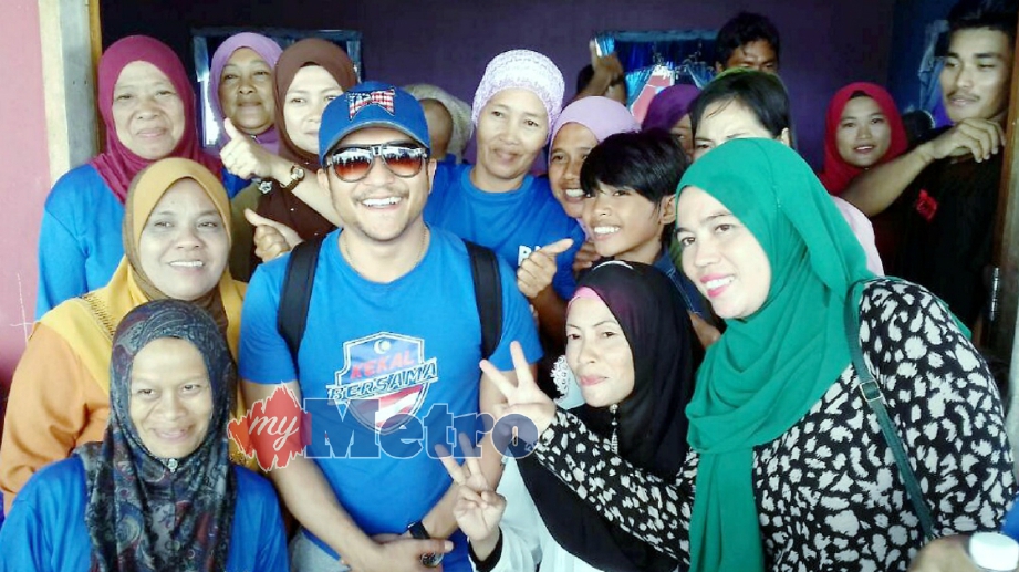 SHAHEIZY Sam bergambar bersama penduduk ketika membantu kempen calon BN Parlimen Kinabatangan, Datuk Seri Bung Moktar Radin. FOTO Hayati Nasrah