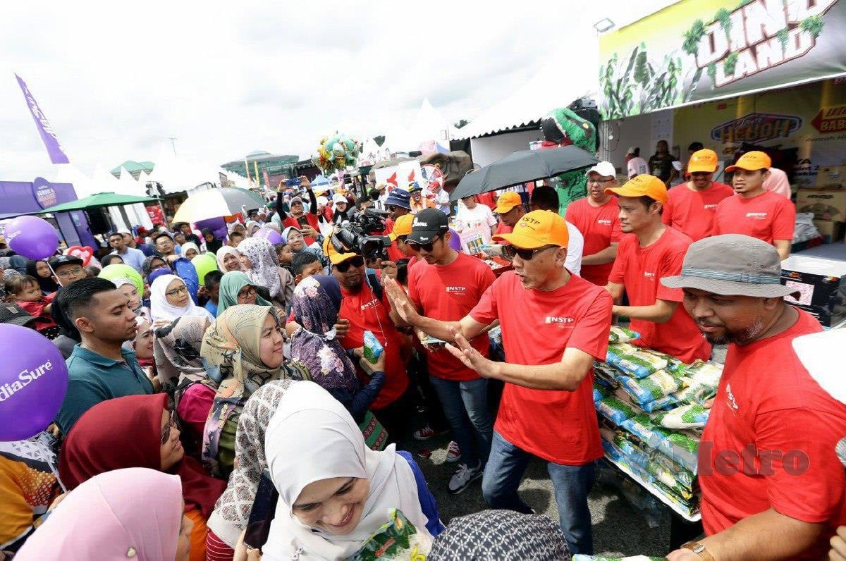 Pengarang Urusan Kumpulan The New Straits Times Press (Malaysia) Berhad (NSTP), Datuk Ahmad Zaini Kamaruzzaman meminta pengunjung bersabar sebelum pemberian beras secara percuma kepada pengunjung ketika majlis perasmian reruai NSTP yang berkonsepkan haiwan replika "dinosaur" dan pemberian hampir seribu beras dan roti yang diberi secara percuma sempena Karnival Jom Heboh di Putrajaya. FOTO MOHD FADLI HAMZAH