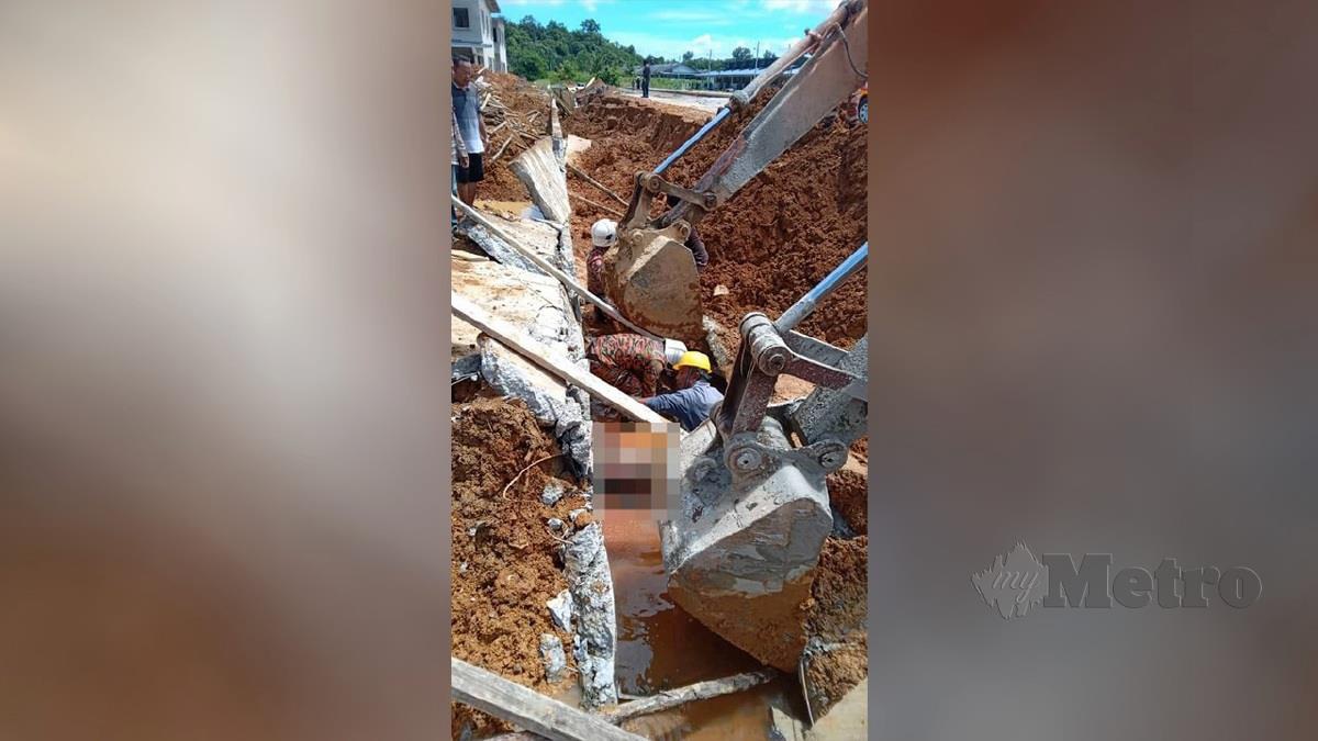 Pasukan bomba sedang berusaha mengeluarkan mayat kedua-dua mangsa yang maut selepas dihempap dinding konkrit parit yang sedang dalam pembinaan di Lorong Samarindah Kota Samarahan pagi tadi. FOTO PGO Sarawak
