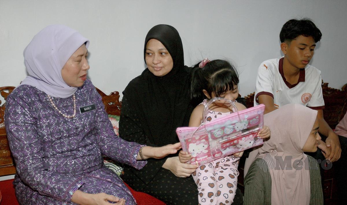 Menteri Pembangunan Wanita, Keluarga dan Masyarakat, Datuk Seri Nancy Shukri (kiri) menziarahi keluarga Nor Pahidah Mat Zaman (dua kiri) isteri kepada mangsa yang maut dalam kejadian dihempap pokok selasa lalu di Seksyen 24, Shah Alam. FOTO FAIZ ANUAR