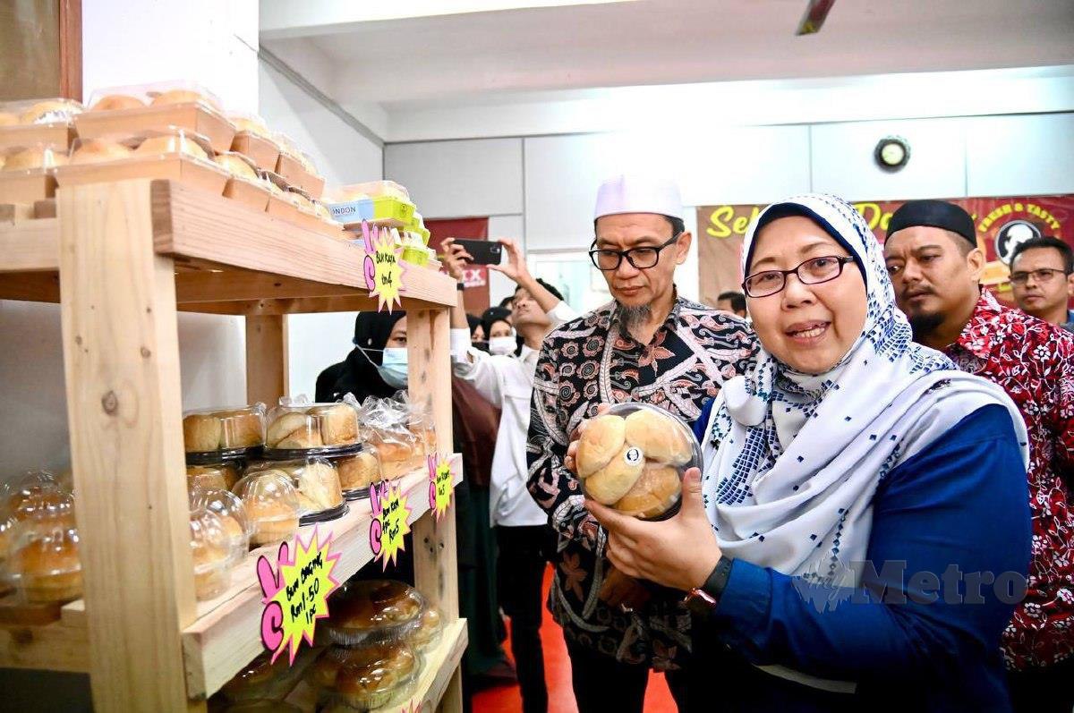 Fuziah menunjukkan roti yang dihasilkan oleh Kilang Roti HPA Industries selepas beliau merasmikan kilang berkenaan di Taman Sena Indah, Kangar. FOTO AIZAT SHARIF