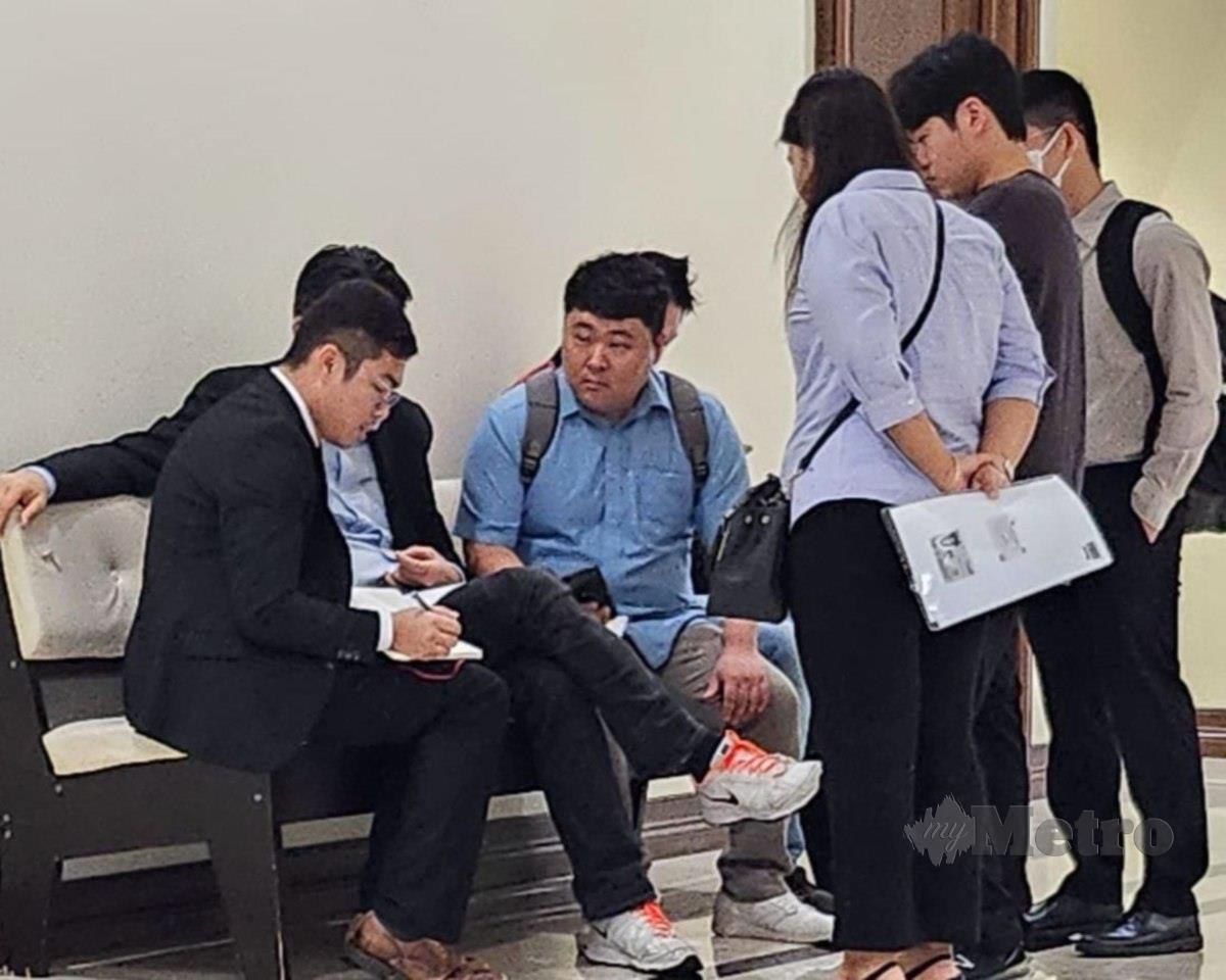 Warga Korea, Lee Chang Whan, 33, (baju biru) menghadiri pertuduhan berkaitan dokumen palsu di Mahkamah Majistret Kota Kinabalu. FOTO IZWAN ABDULLAH