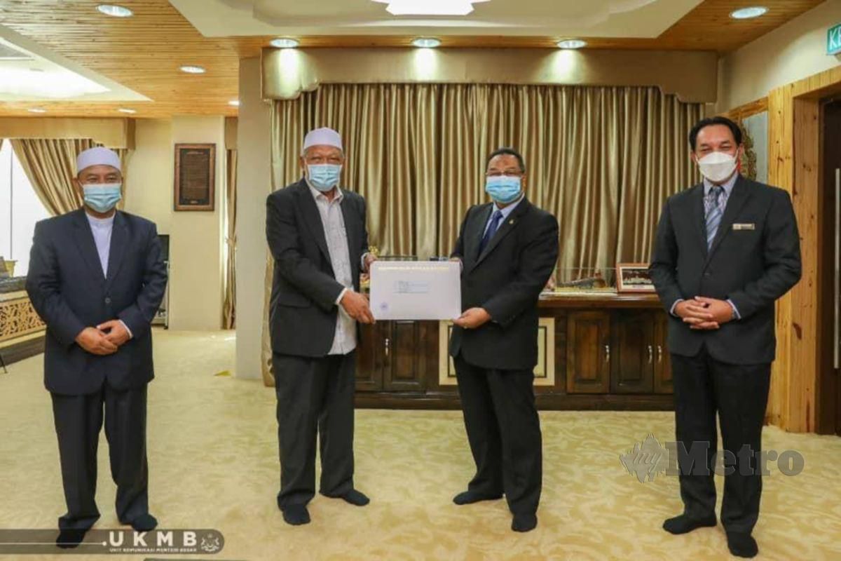 Menteri Besar Kelantan Datuk Ahmad Yakob (dua kiri) menerima kurniaan sumbangan RM300,000 daripada Sultan Muhammad V yang disampaikan oleh Penglola  Istana D'Raja Kelantan Datuk Tengku Azmi Tengku Jaafar (dua kanan). FOTO FACEBOOK DATUK AHMAD YAKOB