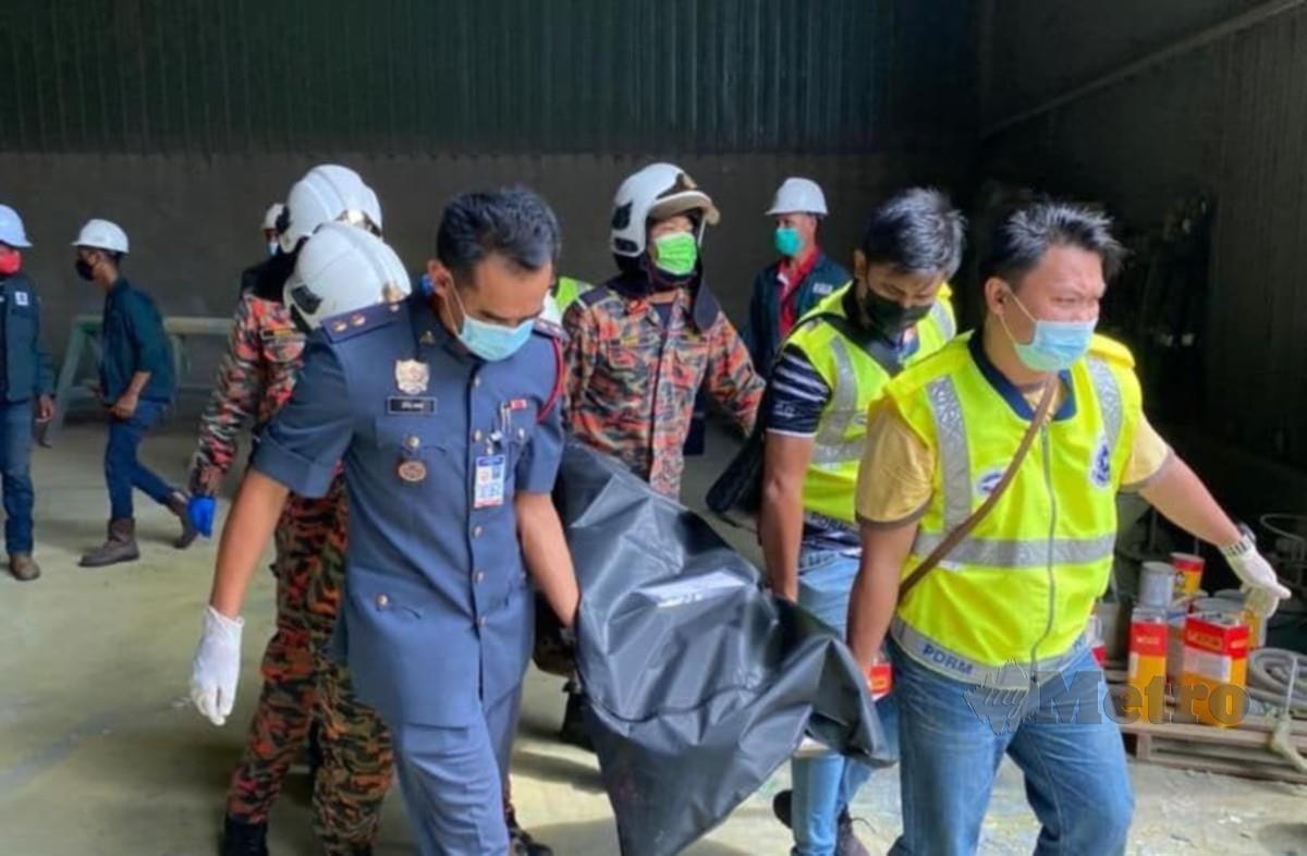 Pasukan penyelamat terdiri daripada polis dan bomba membawa mayat mangsa yang dihempap sebatang paip saluran gas di Kawasan Perindustrian Teluk Kalong. FOTO IHSAN BOMBA