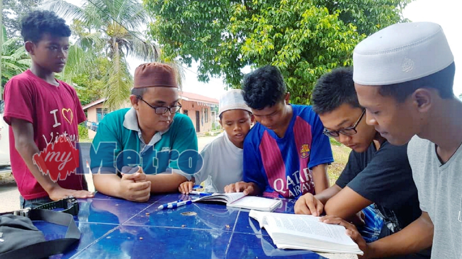 ORANG Asli, Nomi Jantan, 21, (tiga kanan) bersama adiknya, Mohd Nor, 19, (kanan) dari suku kaum Semaq Beri dan rakan yang lain berkongsi buku bagi mengulang kaji mengenai Islam di Pusat Latihan dan Dakwah Orang Asli (PULDOA) Islamic Outreach ABIM Kelantan, Kok Lanas. FOTO Mohd Zulkifli Zainuddin