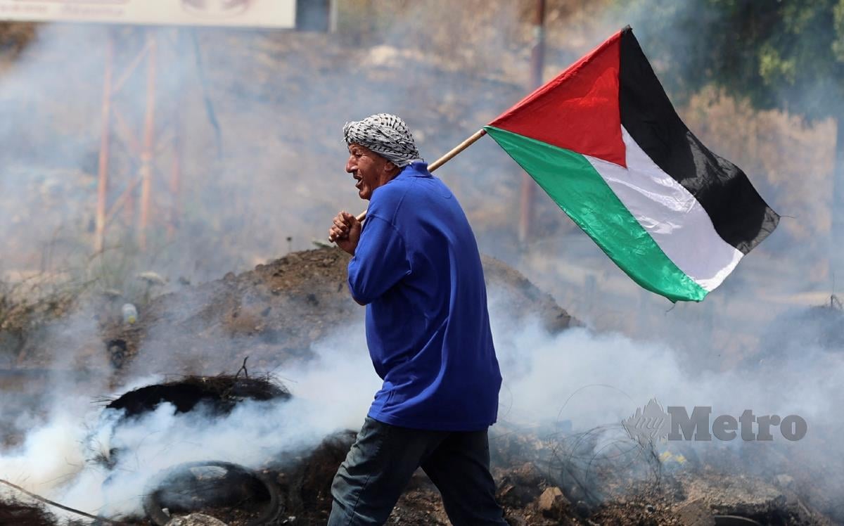 RAKYAT Palestin tetap mengibarkan bendera negara itu meskipun sedang bertempur dengan tentera Israel yang mencurangi perjanjian gencatan senjata. FOTO AFP