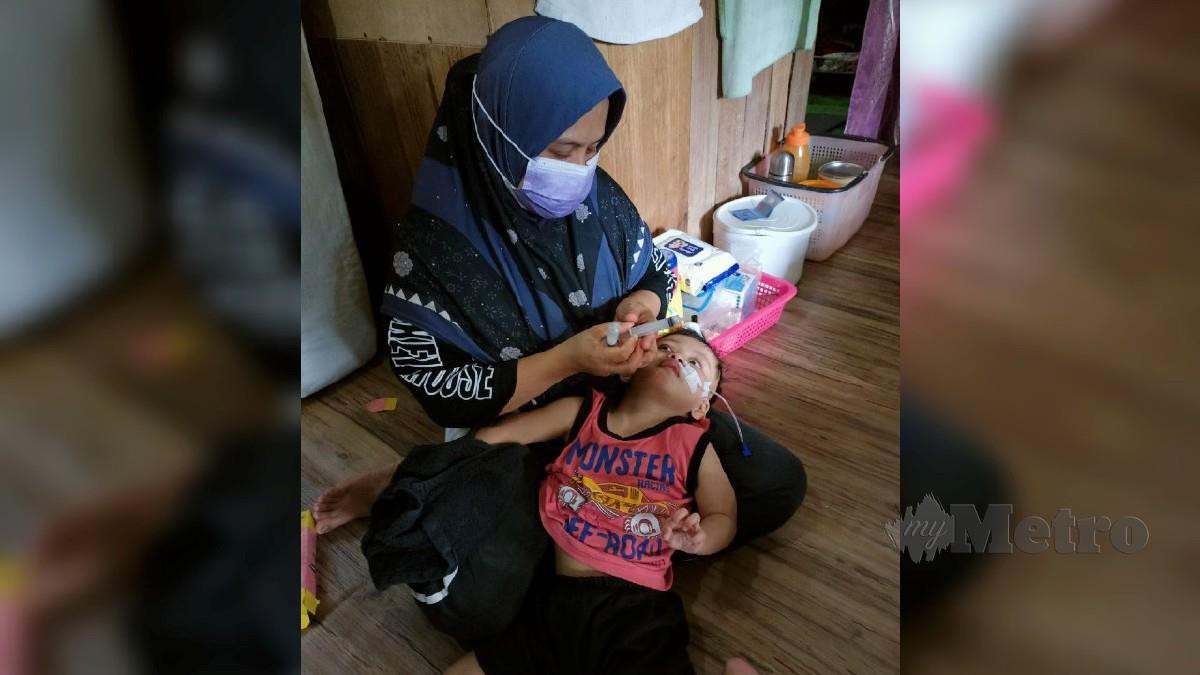 Wan Azizah Wan Yusoff memberi susu kepada Muhammad Al Idrus, melalui wayar yang dipasang melalui hidung. FOTO Paya Linda Yahya