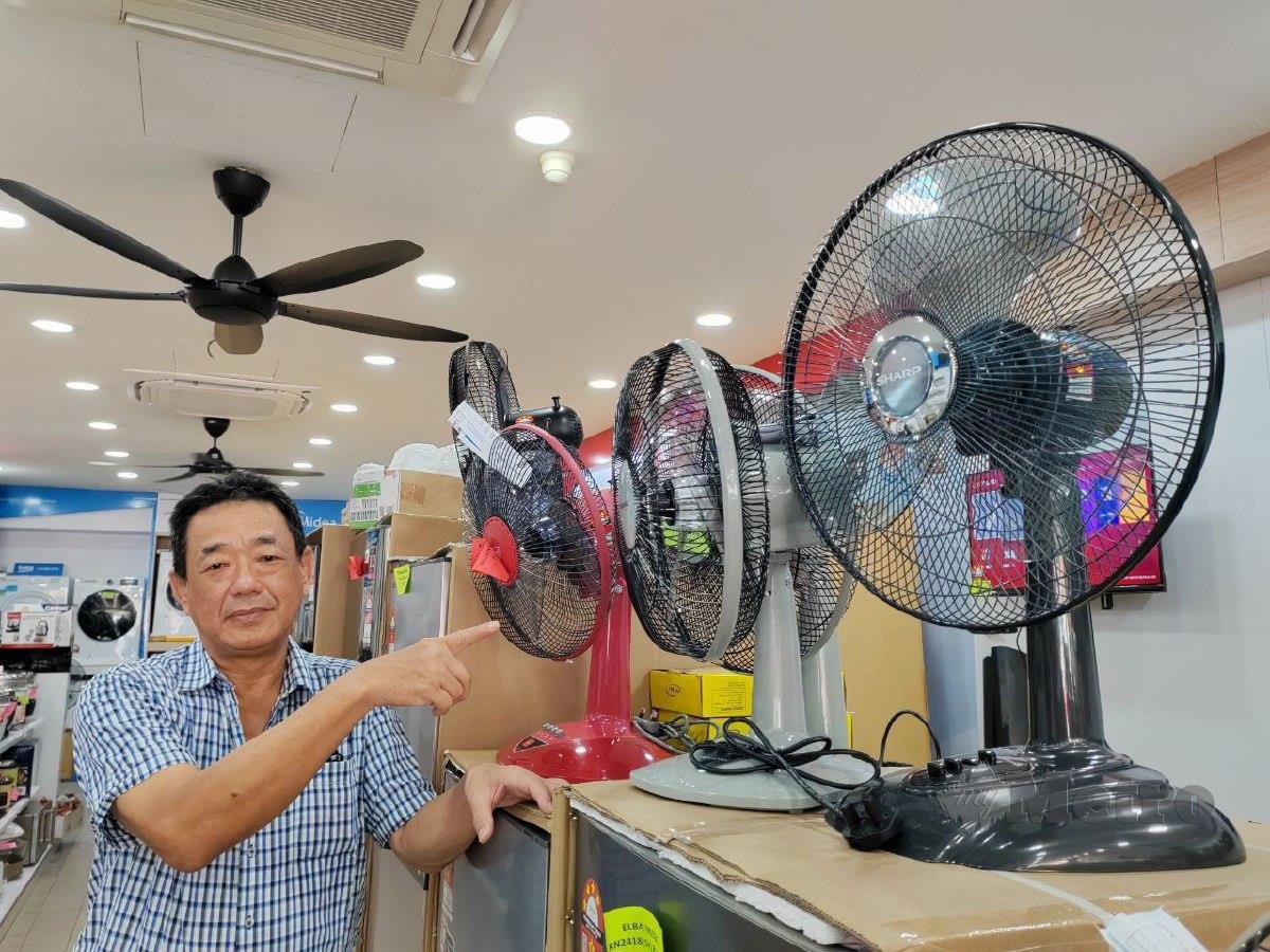 Pemilik premis barangan elektrik Calvin Tan menunjukkan kipas yang menjadi antara barang terlaris di kedainya susulan cuaca panas dan kering. FOTO NOOR HIDAYAH TANZIZI.