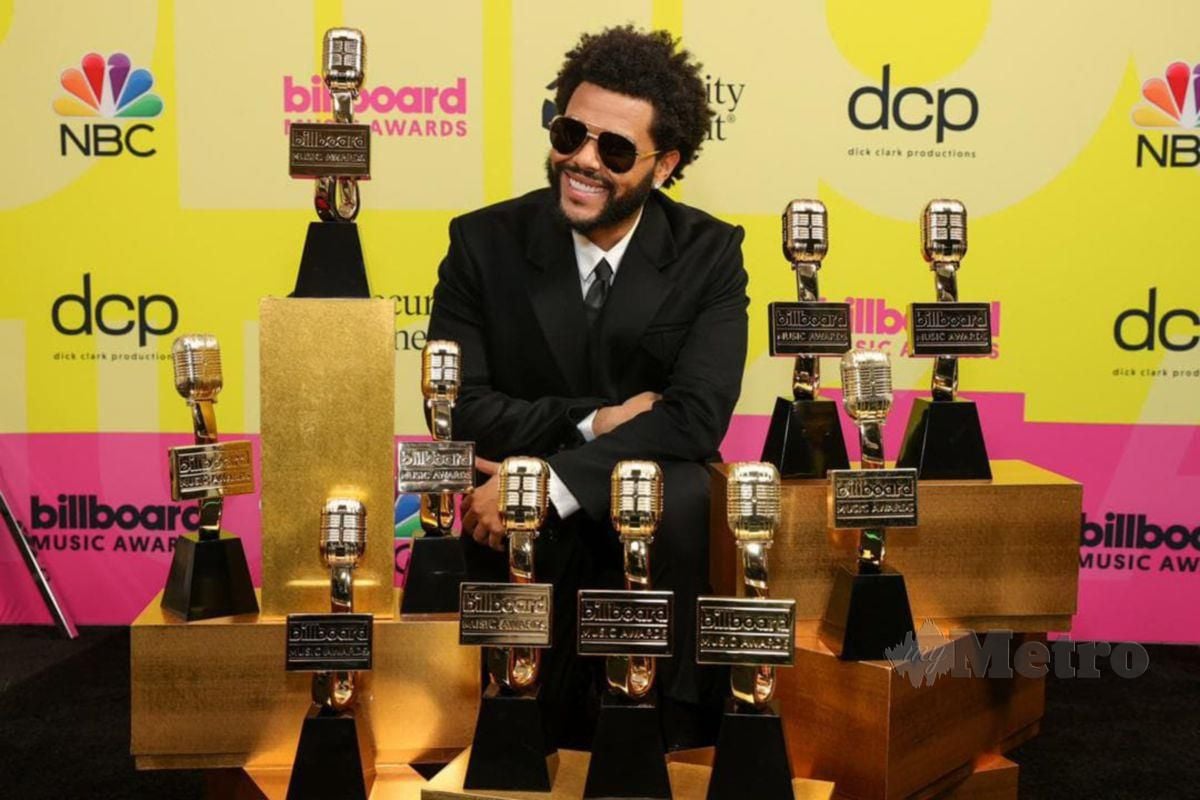 The Weeknd bersama trofi dimenangi.