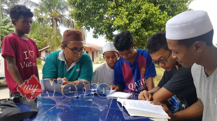MUALAF dari kaum Cina Iban, Abdul Wahid Song Sii Chong, 29 (dua dari kiri) bersama rakannya berkongsi buku bagi mengulang kaji mengenai Islam di Pusat Latihan dan Dakwah Orang Asli (PULDOA) Islamic Outreach ABIM Kelantan, Kok Lanas. FOTO Zulkifli Zainuddin
