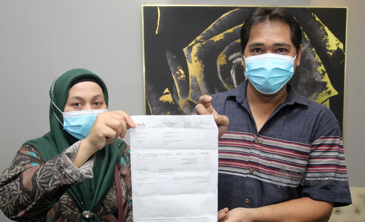 Peniaga colek, Mohd Azizi Md Nor, 42 (kanan) bersama isterinya Nik Nawati Nik Lah, 38 (kiri) menunjukkan surat rayuan kompaun yang berjaya dikurangkan kepada RM500  hasil rayuan yang dibuat menerusi Sekretariat Perundangan dan Peguam Muda Pergerakan Pemuda UMNO Malaysia ketika ditemui di pejabat Pergerakan Pemuda UMNO Bahagian Pengkalan Chepa. FOTO NIK ABDULLAH NIK OMAR