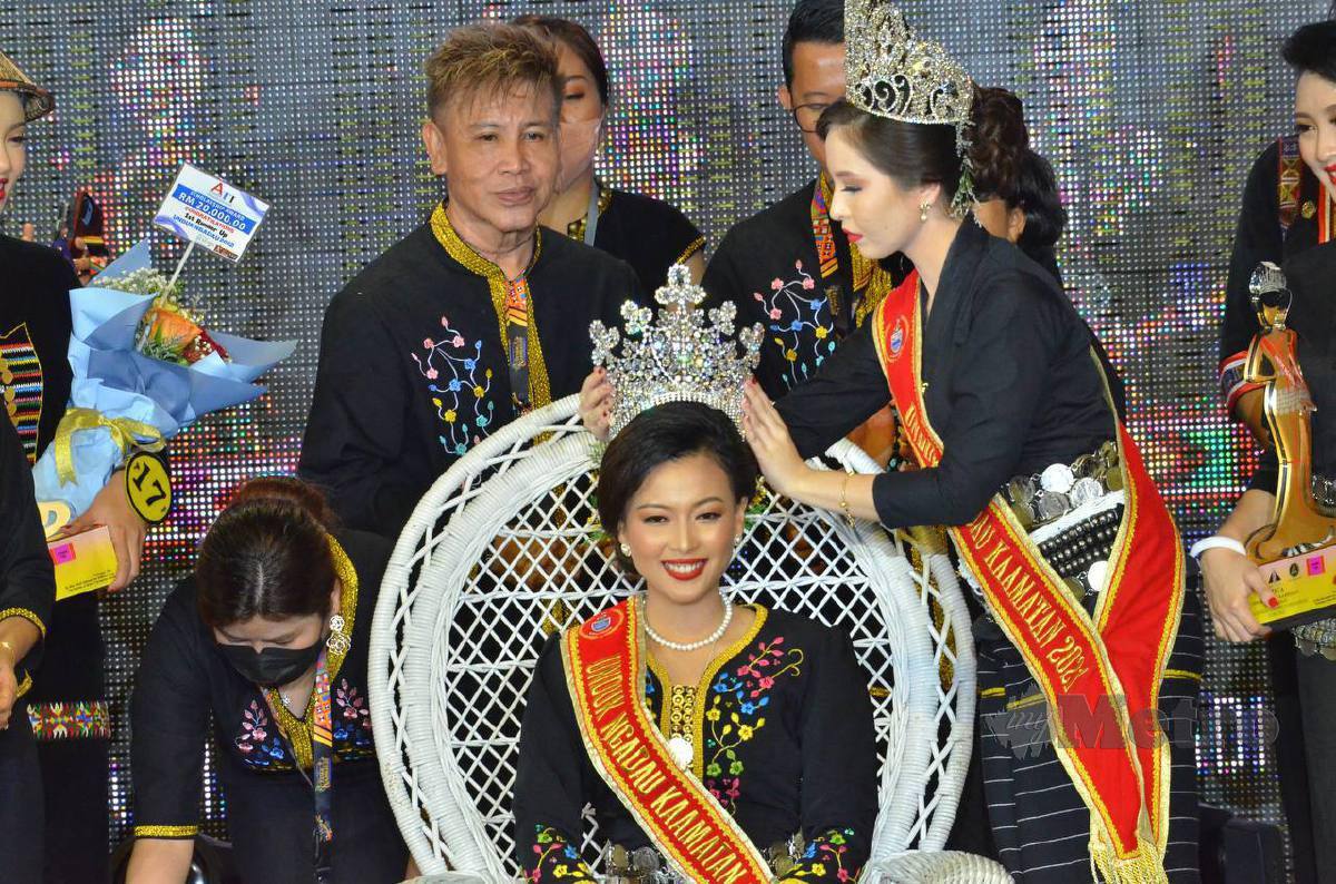 Unduk Ngadau 2021, Maya Hejnowska (kanan) memakaikan mahkota kepada pemenang Unduk Ngadau 2022 yang mewakili Sandakan, Frenerietta Sobitun (duduk) di Hongkod Koisaan sempena penutupan Pesta Kaamatan peringkat negeri hari ini. FOTO MOHD ADAM ARININ