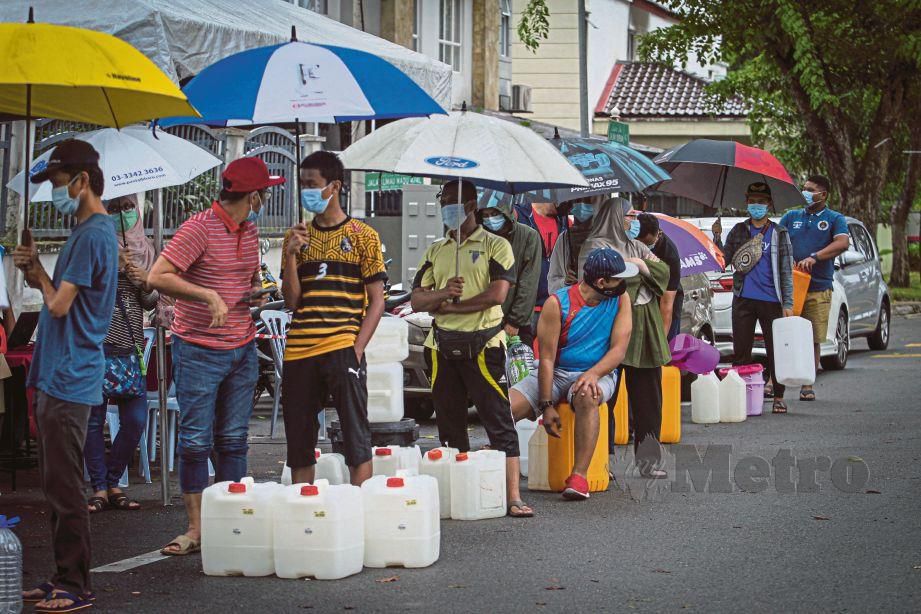 ORANG ramai beratur dan mengambil air di Pusat Khidmat Setempat Pengurusan Air Selangor Sdn Bhd yang di buka di hadapan Dewan Bola Tampar Majlis Bandaraya Shah Alam. FOTO Aziah Azmee