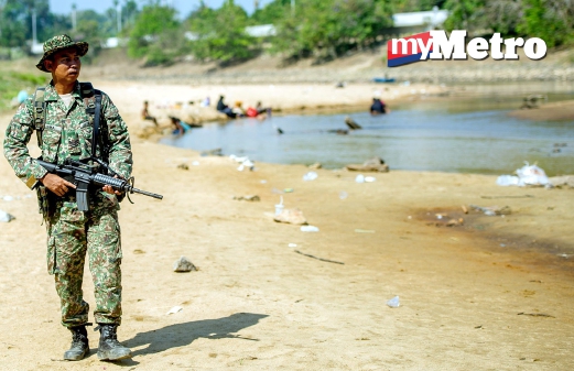 SEORANG anggota tentera dari Batalion Ke 5 Rejimen Sempadan Kem Bukit Kayu Hitam Kedah mengawal di kawasan sempadan Malaysia Thailand di Sungai Golok hari ini. FOTO Bernama