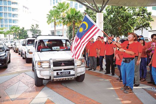 IBRAHIM mengibarkan bendera Malaysia sebagai simbol pelepasan misi Kembara Jalinan Kasih K1M untuk membantu membersihkan kesan kerosakan akibat banjir di pantai timur.