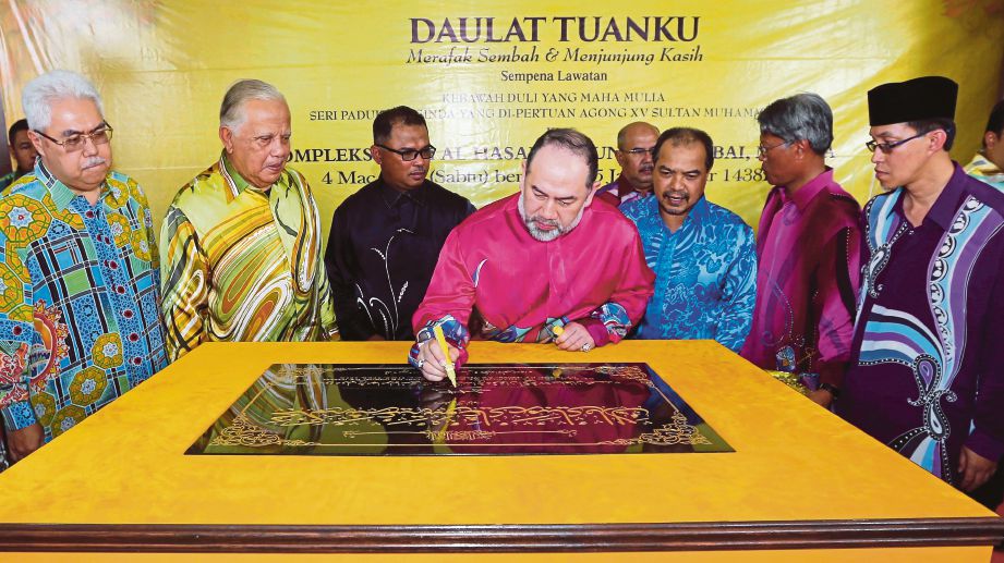 Sultan Muhammad V menandatangani plak perasmian Mahkamah Syariah sambil diperhatikan  Mohd Khalil  (dua dari kiri),   Jamil Khir  (tiga dari kanan) dan  Idris  (tiga dari kiri), semalam.