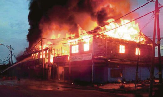 KEPULAN asap memenuhi  lokasi deretan lima kedai terbakar, semalam.