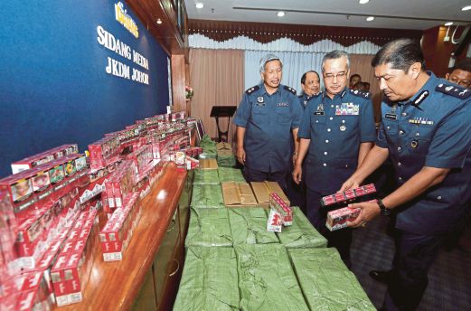 RAMLI (dua dari kanan) melihat rokok jenama terkenal bernilai RM3.3 juta dirampas di PTP.