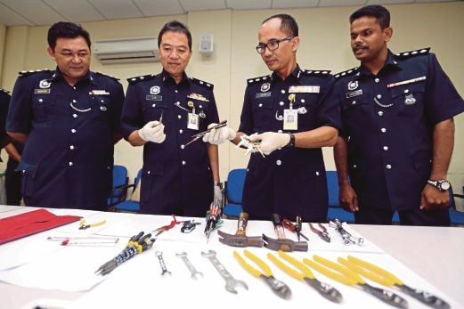 Mohammad Azlin  (dua dari  kanan) bersama pegawainya  menunjukkan peralatan yang digunakan sindiket  di Ibu Pejabat Polis Daerah Subang Jaya. 