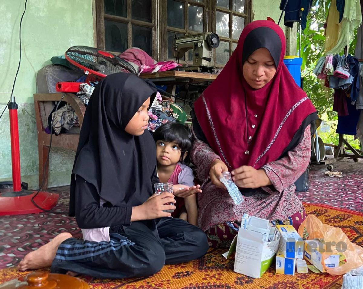 SUHADA perlu memberikan ubat kepada Siti Aufa setiap hari akibat penyakit buah pinggang, darah tinggi dan sawan ketika ditemui di rumahnya di Kampung Stong, Kuala Krai. Foto Hazira Ahmad Zaidi