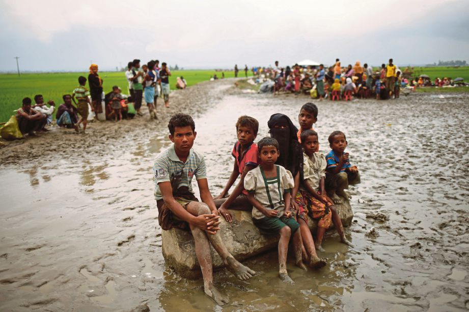 PELARIAN Rohingya  menunggu tindakan selanjutnya oleh pengawal sempadan selepas melintas sempadan di Teknaf, Bangladesh. - Reuters  