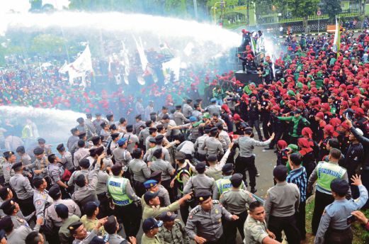 GAMBAR fail menunjukkan ribuan pekerja Indonesia berdepan dengan polis  pada satu tunjuk perasaan menuntut kenaikan gaji minimum di Cibinong, Jawa Barat,  24 November lalu.
