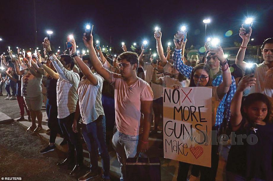 ORANG ramai membuat bantahan memegang sepanduk  berbunyi: 'Tiada lagi senjata api.’ - Daily Mail