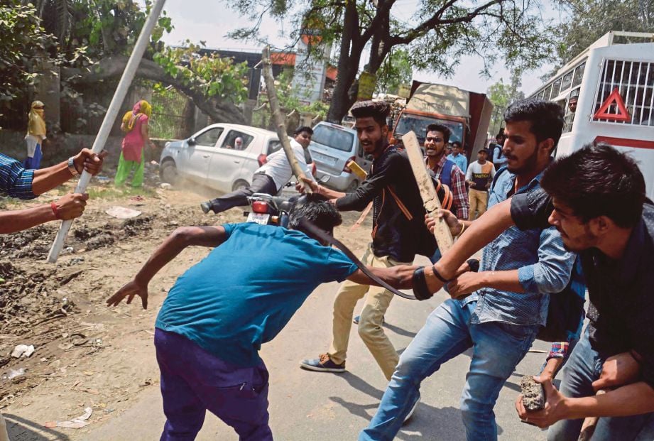 DUA kumpulan perusuh bertempur di Meerut, Uttar Pradesh, kelmarin. - AFP