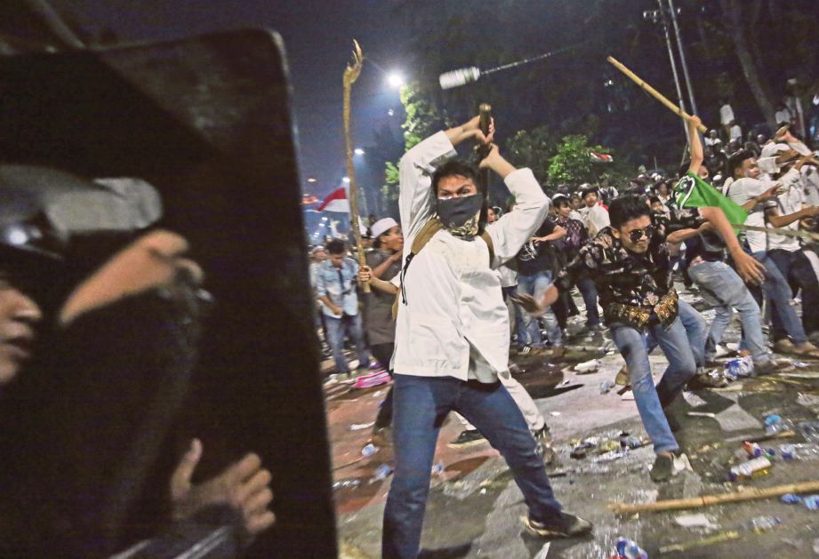 PENUNJUK perasaan menyerang polis di luar Istana Presiden. - AFP 